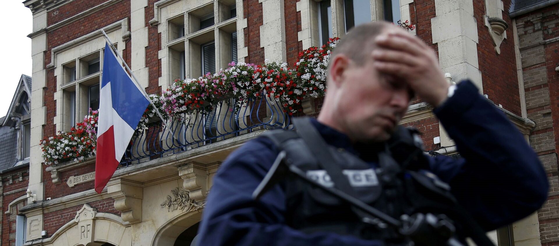 A policeman reacts as he secures a position in front of the city hall after two assailants had taken five people hostage in the church at Saint-Etienne-du -Rouvray near Rouen in Normandy, France, July 26, 2016.  - Sputnik Moldova-România, 1920, 22.06.2021