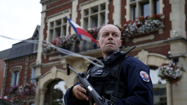 A policeman secures a position in front of the city hall after two assailants had taken five people hostage in the church at Saint-Etienne-du -Rouvray near Rouen in Normandy, France, July 26, 2016 - Sputnik Moldova