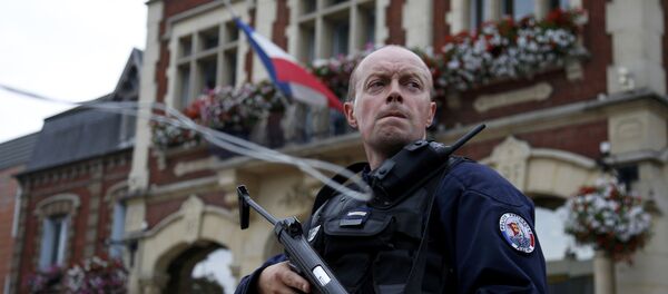 A policeman secures a position in front of the city hall after two assailants had taken five people hostage in the church at Saint-Etienne-du -Rouvray near Rouen in Normandy, France, July 26, 2016 - Sputnik Moldova