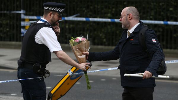 Человек дает цветы сотруднику полиции после атаки ножом на Рассел-сквер в Лондоне - Sputnik Молдова
