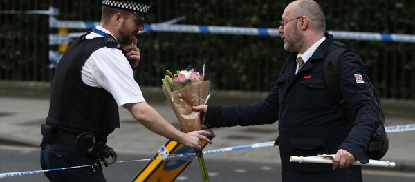 Человек дает цветы сотруднику полиции после атаки ножом на Рассел-сквер в Лондоне - Sputnik Молдова