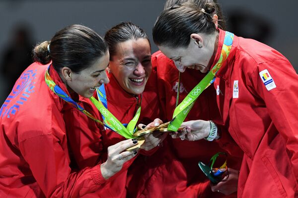 Echipa feminină de scrimă a României sărbătorește pe podium dupa ce a luat aurul la JO de la Rio. Echipa feminină de scrimă a României sărbătorește pe podium dupa ce a luat aurul la JO de la Rio. - Sputnik Moldova-România