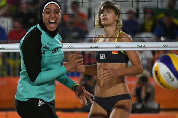 Voleibalista Doaa Elghobashi din Egipt și sportiva Laura Ludvig din Germania în timpul probei eliminatorii la volei de plajă între Germania și Egipt, pe Beach Volley Arena din Rio de Janeiro. - Sputnik Moldova