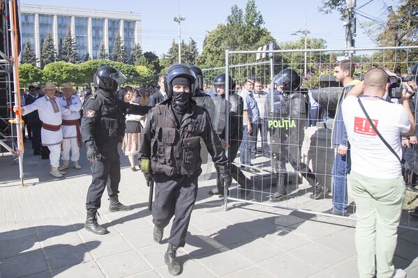 Спецназовцы спешат выстроиться напротив протестующих по ту сторону сетки. - Sputnik Молдова