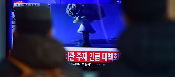 Люди смотрят по телевизору новостной выпуск об испытании ядерного оружия в КНДР - Sputnik Молдова