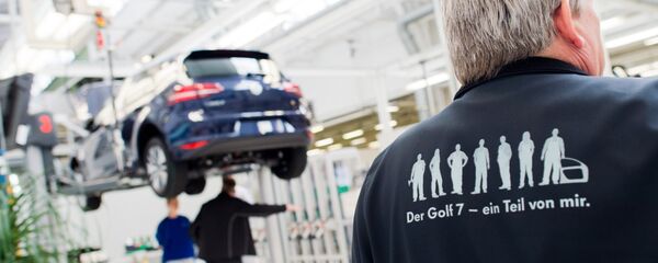 Employees of German car maker Volkswagen (VW) work on an electric car e-Golf at an assembly line at VW plant in Wolfsburg, central Germany, on October 21, 2015. - Sputnik Moldova-România