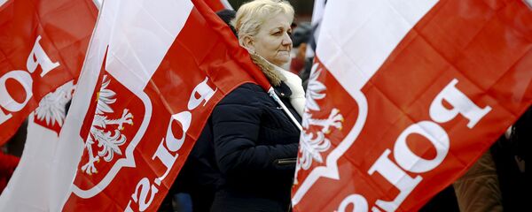 A woman holds the Polish national flag as she takes part in a march demanding their government to respect the country's constitution in Warsaw, Poland, March 12, 2016. - Sputnik Moldova-România
