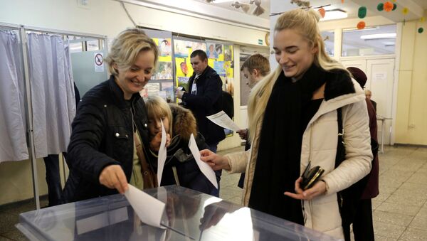 Люди опускают бюллетени в урну на выборах в Вильнюсе, Литва - Sputnik Молдова