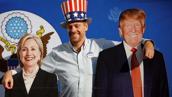 Мужчина позирует с картонными вырезами кандидатов в президенты Хиллари Клинтон и Дональд Трамп - Sputnik Молдова