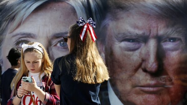 People pause near a bus adorned with large photos of candidates Hillary Clinton and Donald Trump before the presidential debate. - Sputnik Moldova-România