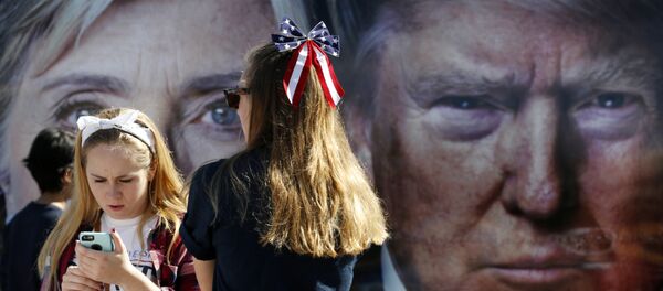 People pause near a bus adorned with large photos of candidates Hillary Clinton and Donald Trump before the presidential debate. - Sputnik Moldova-România