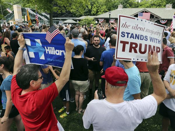 Сторонники Трампа и Клинтон держат в руках плакаты с поддержку своих кандидатов. Чапакуа, штат Нью-Йорк, май 2016 года. - Sputnik Молдова