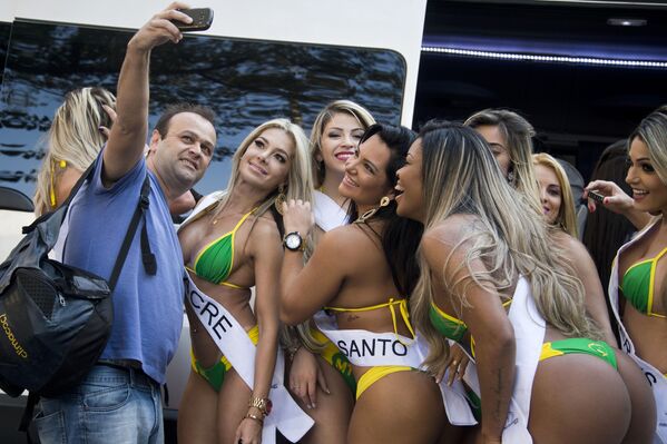 Un bărbat care face selfie alături de candidatele pentru câștigătoarea Miss BumBum 2015, pe Paulista Avenue în Sao Paulo, Brazilia, în data de 3 August 2015, în timpul unui eveniment de promovare a concursului - Sputnik Moldova-România