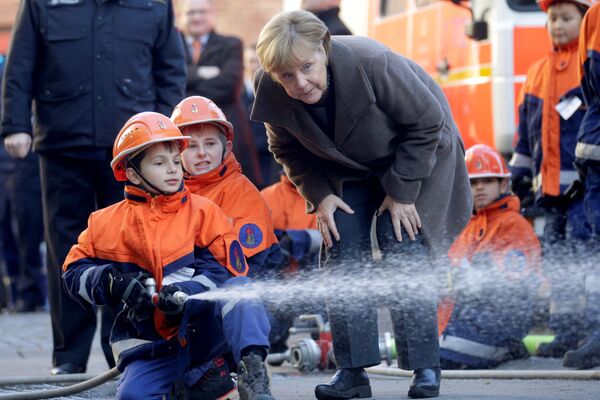 Канцлер Германии Ангела Меркель во время визита к Молодежной пожарной команде в Берлине - Sputnik Молдова
