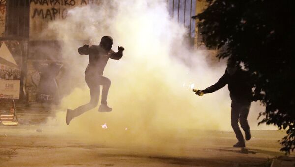 Протестующий уклоняется от заряда со слезоточивым газом во время митинга против визита Барака Обамы в Афины - Sputnik Moldova-România