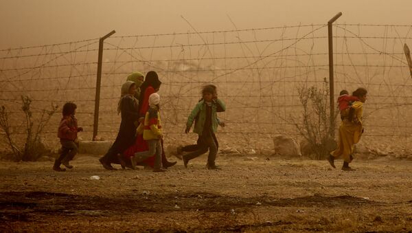 Дети идут вдоль забора во время песчаной бури в лагере беженцев недалеко от деревни Айн Исса, Сирия - Sputnik Moldova-România
